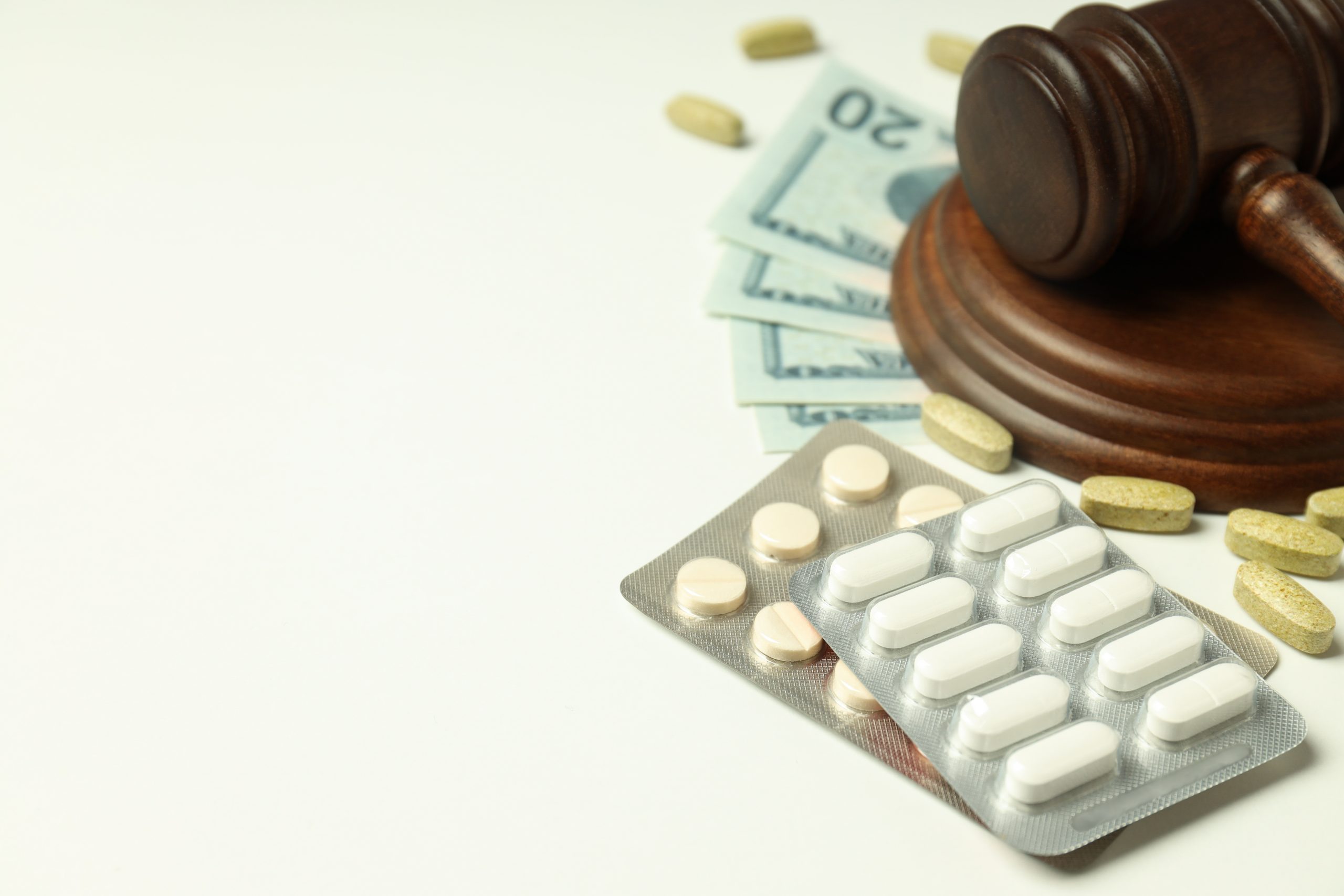 Pills with gavel of justice and money, medical corruption concept.
